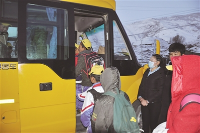 學(xué)生們在老師的引導(dǎo)下依次乘坐校車。 本報記者 王勻 攝