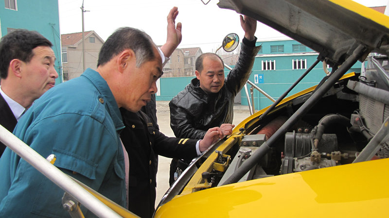 青島開學前溫馨校車安全大檢查/ 檢車人員正在查看校車發動機是否正常