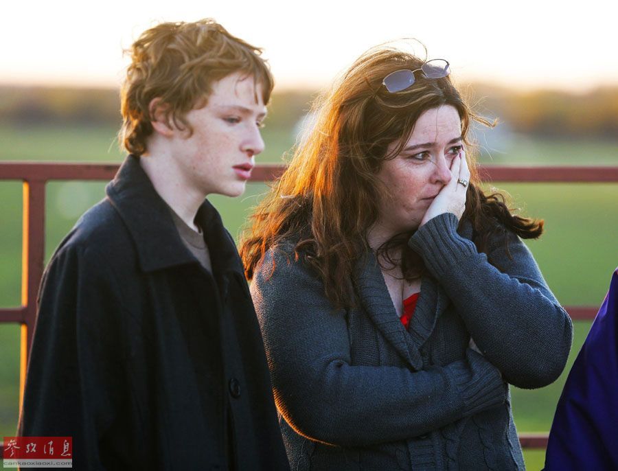 10月31日，在美國堪薩斯州的巴特勒郡，一名家長（右）看著孩子被送上救護(hù)車。當(dāng)日，在巴特勒郡，一輛校車發(fā)生車禍，校車帶著學(xué)生們沖入河中。