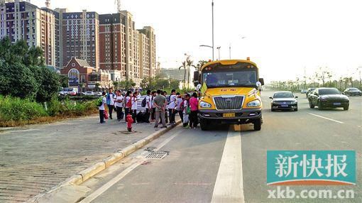 學校旁的鳳凰大道上,家長臨時請來的正規校車正在接送學生。