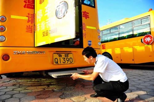 交運溫馨校車黃島分公司一名駕駛員在檢查校車逃生門設置。