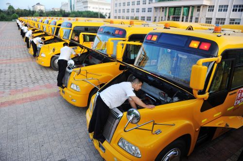 交運溫馨校車黃島分公司駕駛員在檢查和清理校車發動機。 (1)