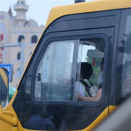 校車路口等紅燈 司機(jī)抱孫坐腿上 司機(jī)抱著孩子