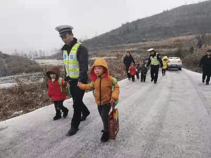 路面冰凍打滑校車受阻,警察“叔叔”牽著13個孩子回家 路面冰凍打滑校車受阻,警察“叔叔”牽著13個孩子回家