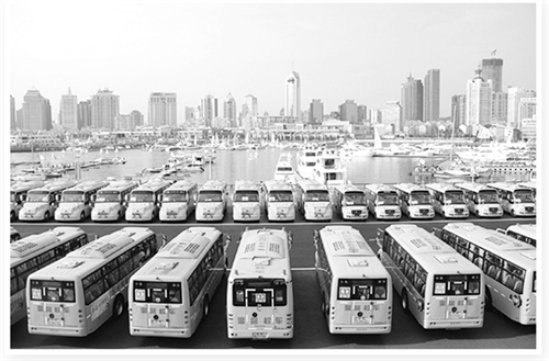 為何非專用校車市場屢禁不止/ 整齊停放在青島市奧帆中心的交運溫馨校車。
